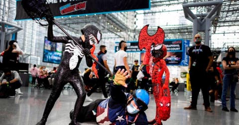 Cris, de 8 años, y Drax Tirado, de 6 años, juegan con un hombre disfrazado de Capitán América en la Comic Con de Nueva York 2021, en el Centro de Convenciones Jacob K.Javits en Nueva York, Nueva York.