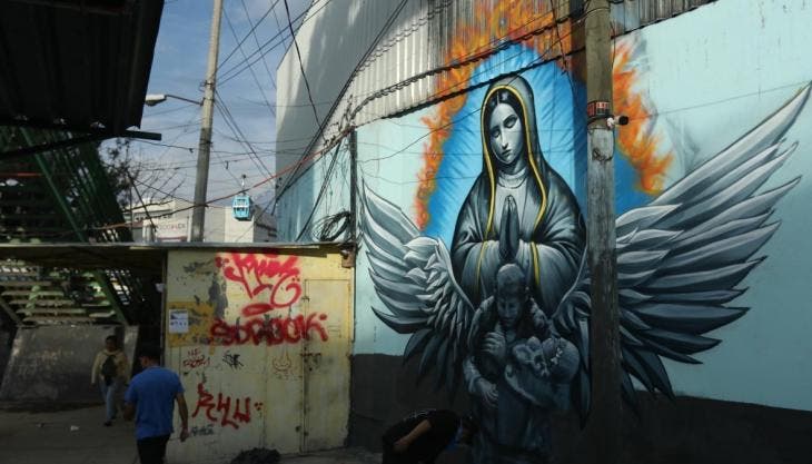 Un hombre camina frente al mural en el paradero de Santa Martha Acatitla en homenaje  a los hechos de La Concordia