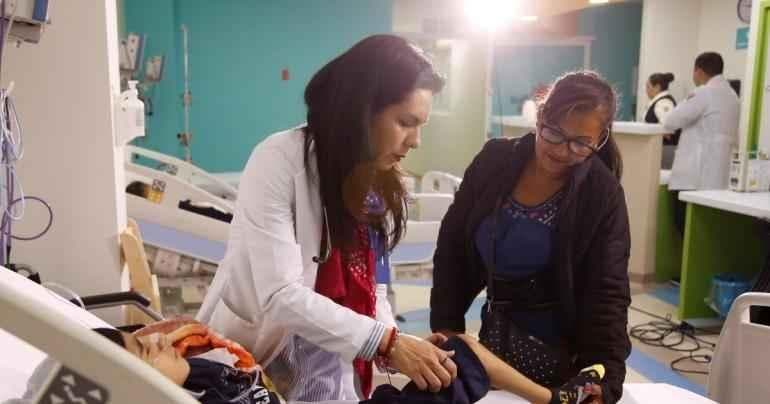 Imagen principal: Una enfermera atendiendo a un paciente dentro de una sala de hospital.