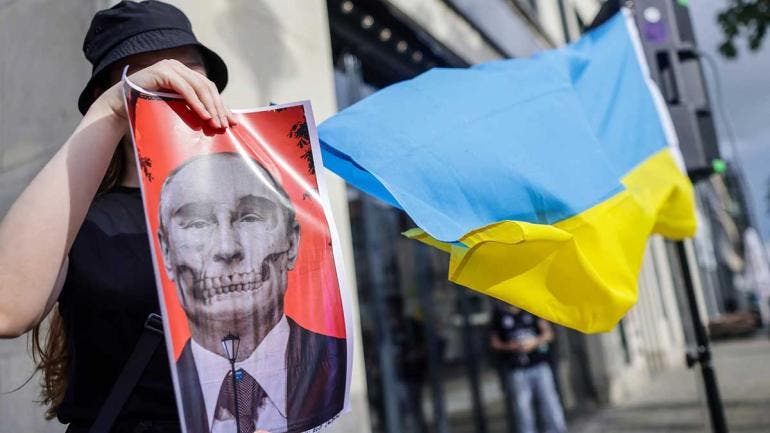 Manifestante muestra banderas de Rusia y Ucrania.