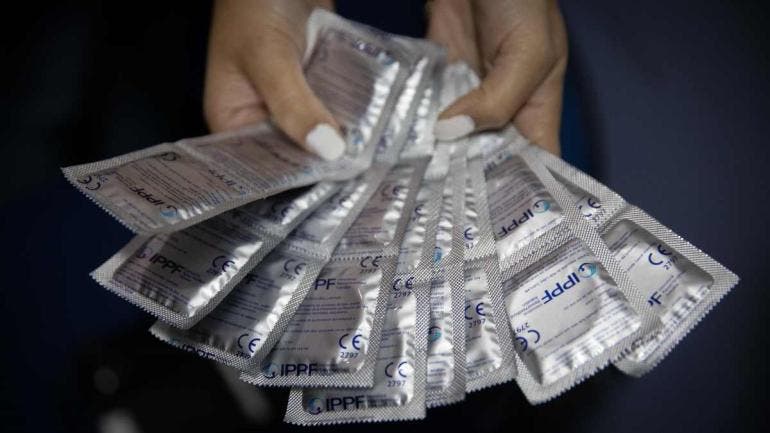 persona que muestra preservativos