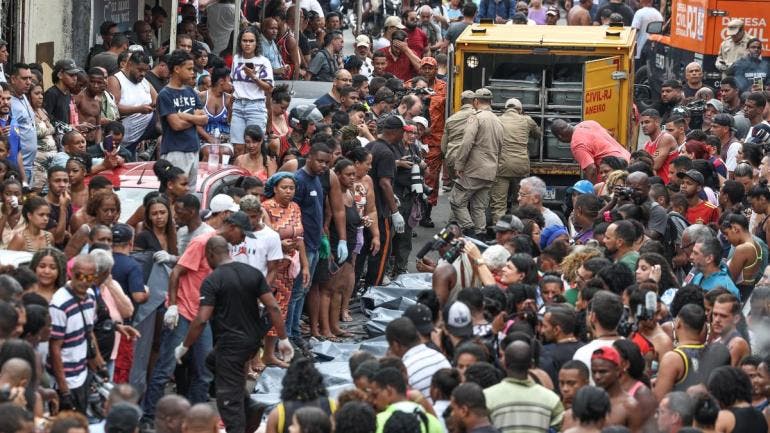 Personas observan cuerpos sin vida en una calle
