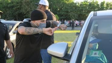 El artista urbano boricua Rauw Alejandro saluda a una persona en su auto como medida de seguridad sanitaria por la Covid-19 durante un evento para repartir regalos hoy, víspera del Día de Reyes, en Puerto Rico.