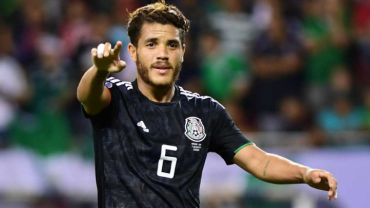 Futbolista levantando la mano mientras mira hacia el público