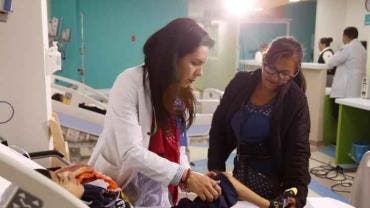 Imagen principal: Una enfermera atendiendo a un paciente dentro de una sala de hospital.