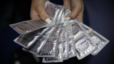 persona que muestra preservativos