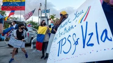 personas con banderas y carteles