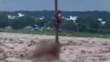 Joven aferrado a un poste tras lluvias