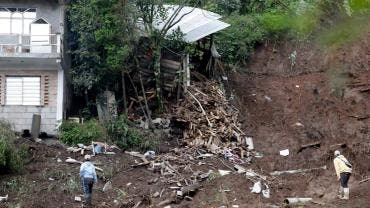 Personas observan una zona afectada por las fuertes lluvias 