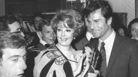 Fotografía de archivo fechada el 20 de junio de 1968 que muestra a la actriz estadounidense Arlene Dahl, vestida con una capa de la Tuna, junto a George Maharis.