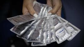 persona que muestra preservativos