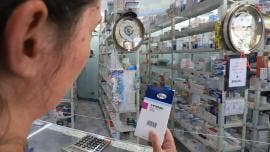 Una mujer muestra una caja de misoprostol en una farmacia