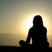 Persona de espaldas contemplando la puesta de sol, simbolizando resiliencia, justicia climática y sostenibilidad en el Caribe, con Marian Vidaurri.