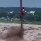 Joven aferrado a un poste tras lluvias