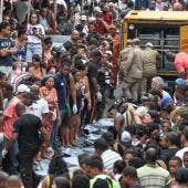 Personas observan cuerpos sin vida en una calle