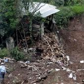 Personas observan una zona afectada por las fuertes lluvias 