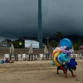 Vendedores caminan en una playa de Acapulco