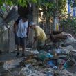 Dos hombres apilan escombros en la calle en el municipio de Álamo 