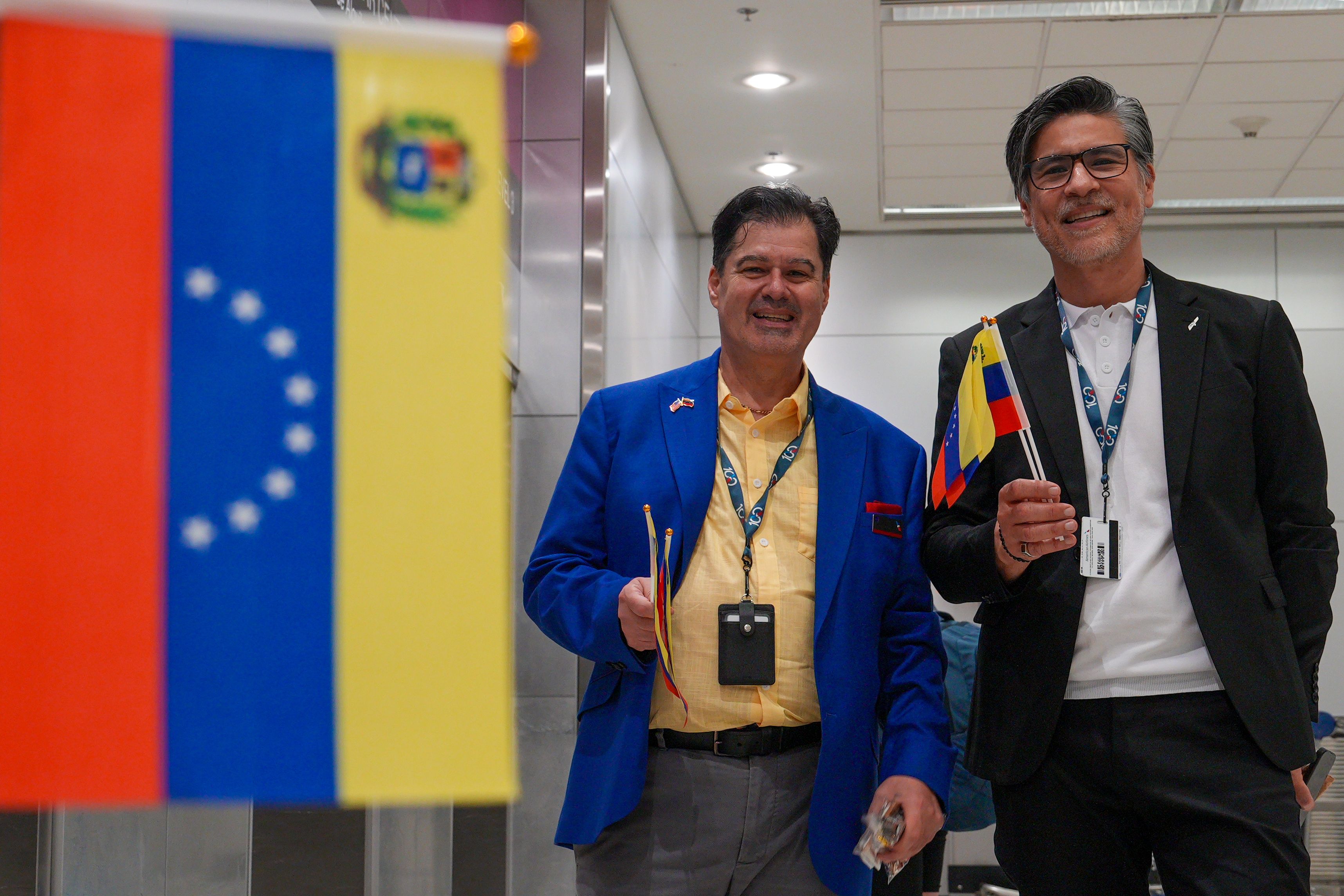 Empleados del American Airlines saludan con banderas venezolanas a los pasajeros del vuelo con destino a Caracas, en el aeropuerto Internacional de Miami en Florida. (EFE)