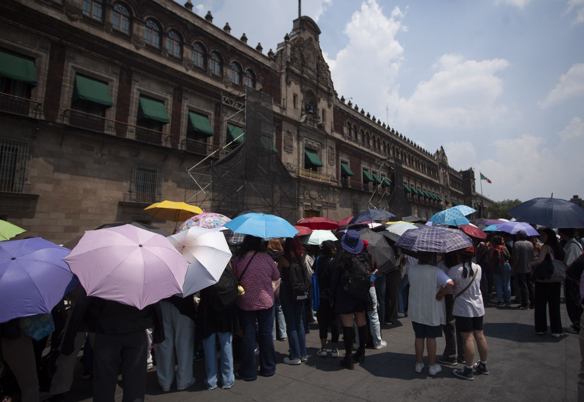 Con sombrillas para soportan la mordida del sol, fanáticos aguardan la llegada de BTS. Cuartoscuro / Andrea Murcia