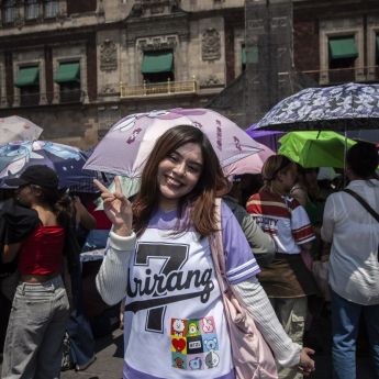 Una fanática posa para la cámara con artículos de la banda surcoreana. Cuartoscuro / Andrea Murcia