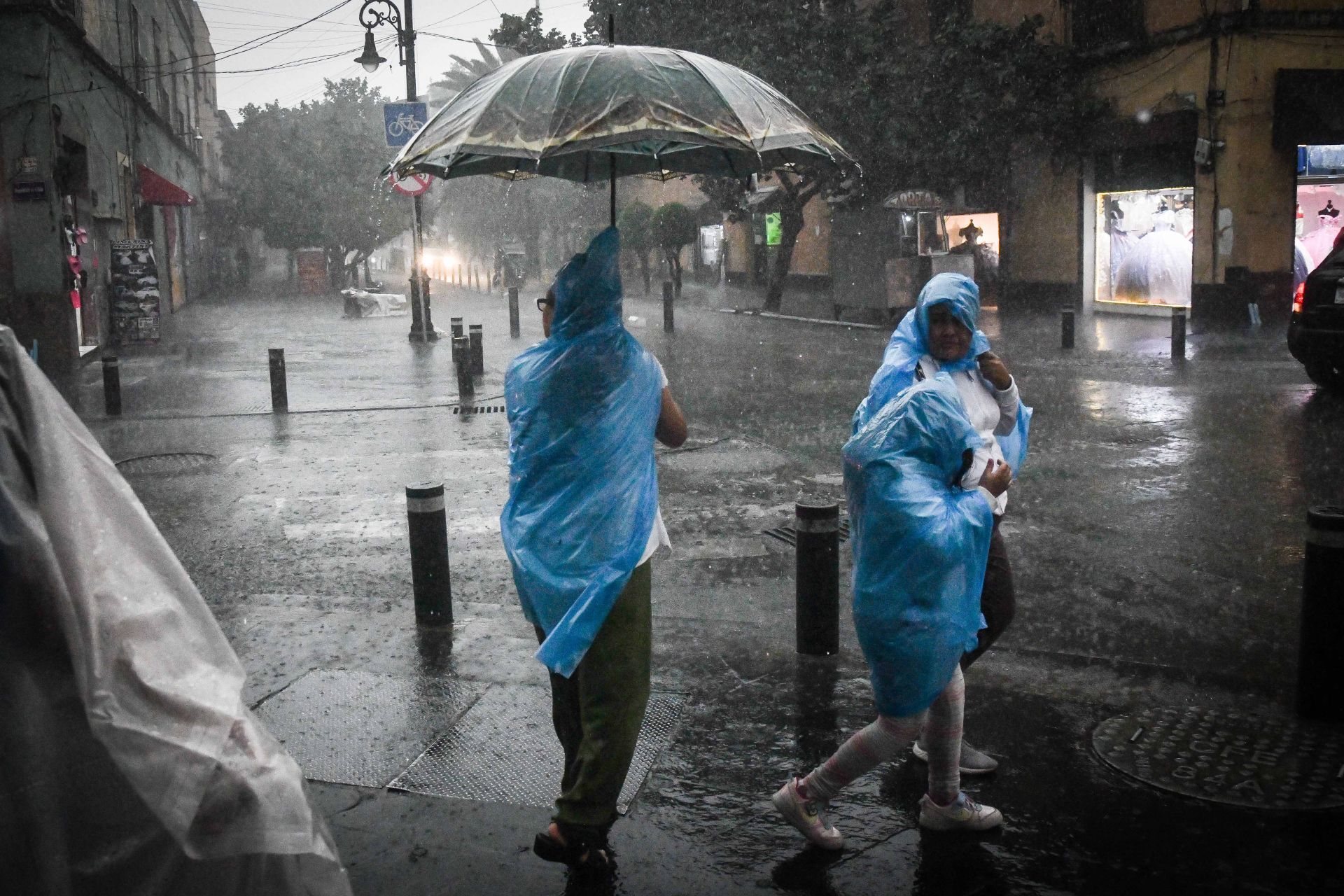 La lluvia de esta tarde agarró por sorpresa a transeúntes, que se protegieron como pudieron. Mario Jasso / Cuartoscuro