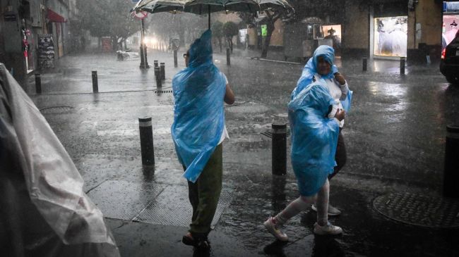 La lluvia de esta tarde agarró por sorpresa a transeúntes, que se protegieron como pudieron. Mario Jasso / Cuartoscuro