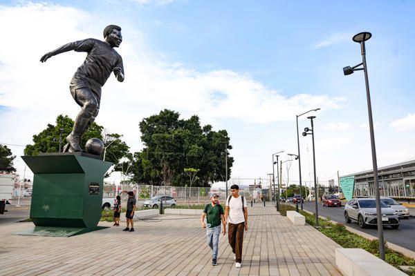 Personas caminan cerca de una escultura en bronce del ex futbolista brasileño Edson Arantes do Nascimento 'Pelé', en Guadalajara. (EFE)