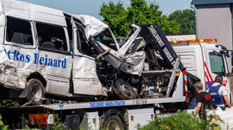 La furgoneta de transporte escolar accidentada es remolcada en el lugar de una colisión con un tren en un cruce ferroviario en Buggenhout, Bélgica. (EFE)