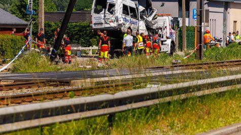 La furgoneta de transporte escolar accidentada es remolcada en el lugar de una colisión con un tren en un cruce ferroviario en Buggenhout, Bélgica. (EFE)