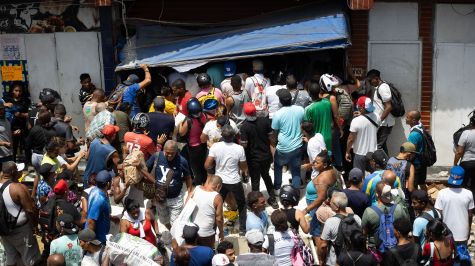 Personas hacen saqueos este viernes, a un establecimiento comercial en Catia La Mar, Venezuela. (EFE).