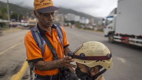 Sebastián Porta un casco con linterna, lentes de protección, un chaleco con la bandera venezolana 