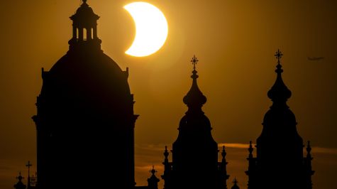 El eclipse solar parcial, con la Basílica de San Nicolás en primer plano, en el centro de Ámsterdam, Países Bajos, el 12 de agosto de 2026. (EFE)