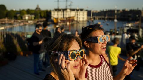 Personas observan el eclipse solar parcial desde la terraza de la azotea del Museo de Ciencias NEMO, en los Países Bajos, el 12 de agosto de 2026. (EFE)