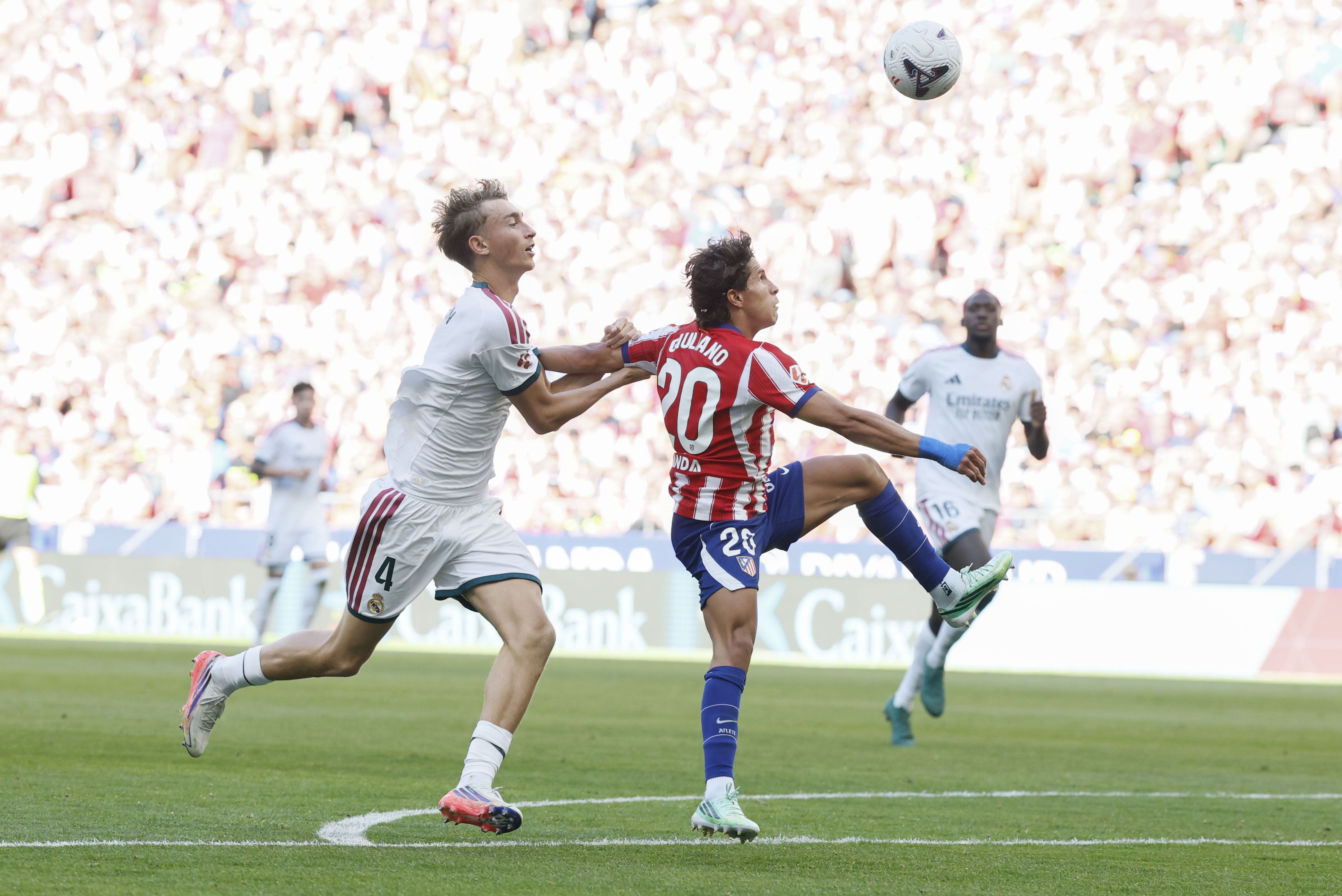 El jalón del zaguero merengue Dean Huijsen a Giuliano Simeone en el área.