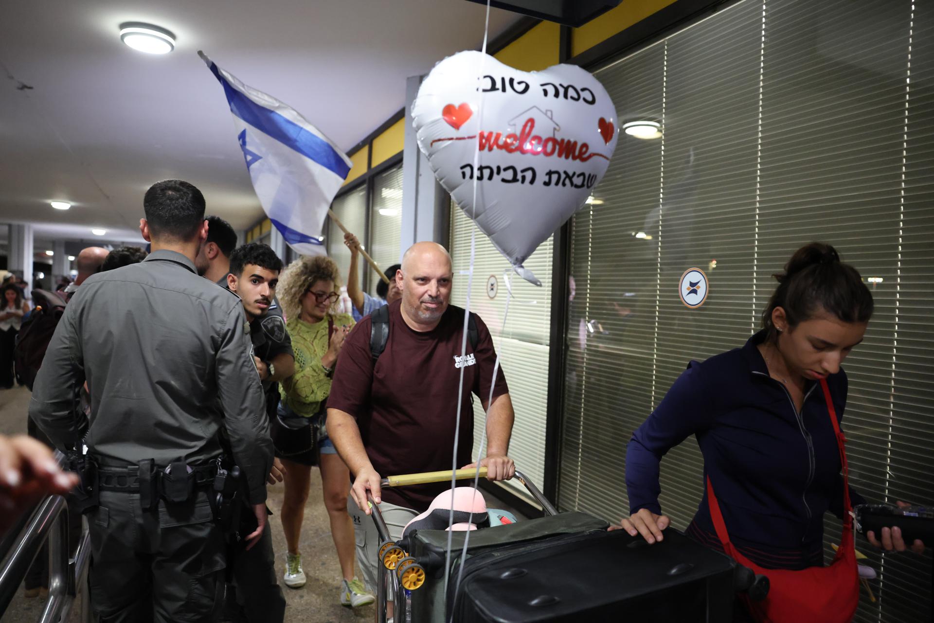 En la terminal de entrada, decenas de familiares y allegados esperaban con globos, banderas israelíes y al grito de "El pueblo de Israel vive"