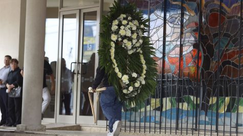Una persona sostiene una corona fúnebre en el lugar donde es velada la maestra Nery Edith Nevárez González, asesinada ayer por dos exalumnos al interior de la escuela secundaria General número 13, en Torreón. (EFE)