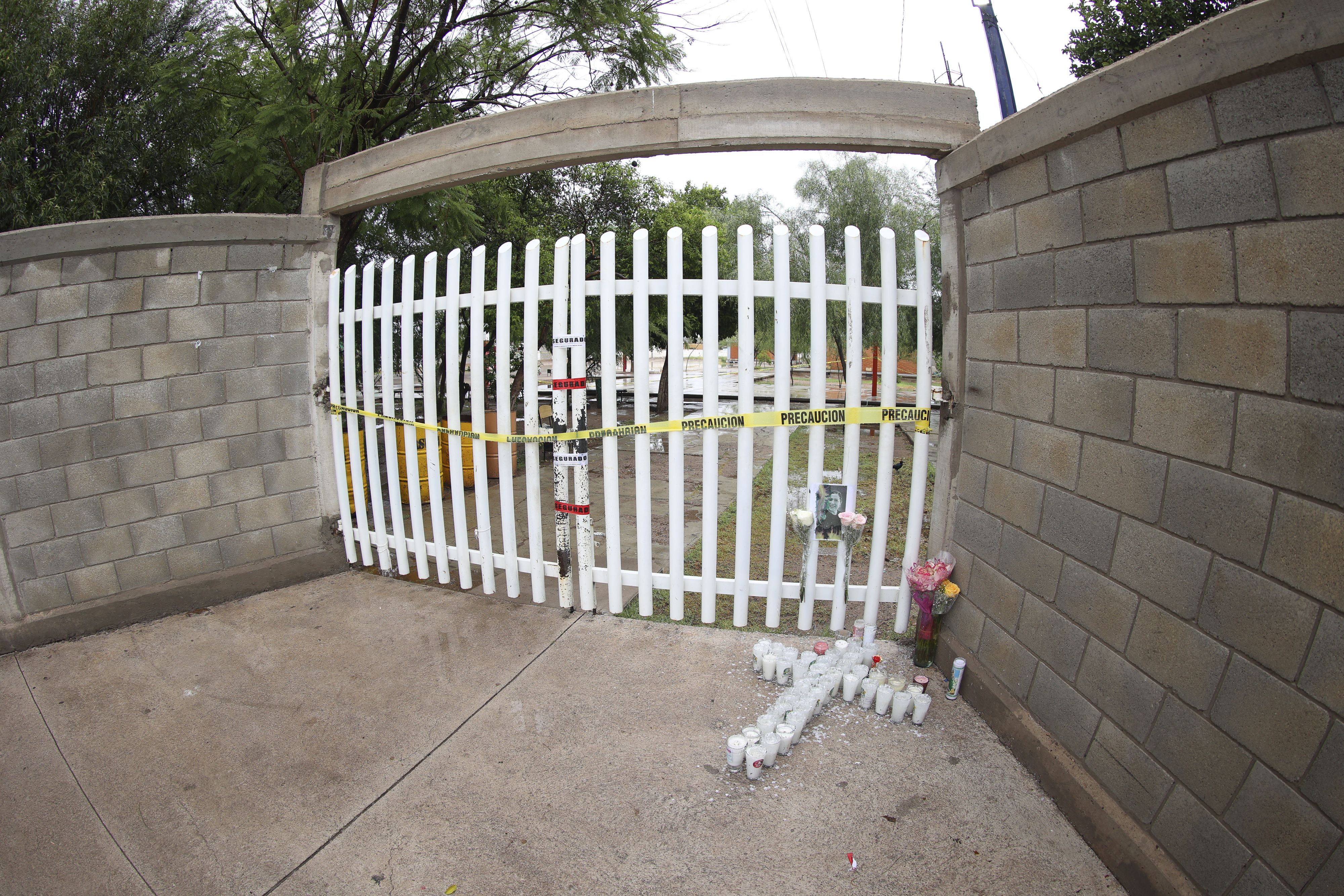 Fotografía de veladoras y flores en la puerta de la secundaria General número 13, en memoria de la maestra Nery Edith Nevárez González, asesinada por dos exalumnos al interior de la escuela secundaria General número 13, en Torreón. (EFE)
