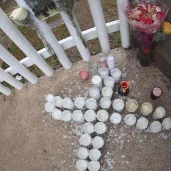 Fotografía de veladoras y flores en la puerta de la secundaria General número 13, en memoria de la maestra Nery Edith Nevárez González, asesinada por dos exalumnos al interior de la institución académica, en Torreón. (EFE)