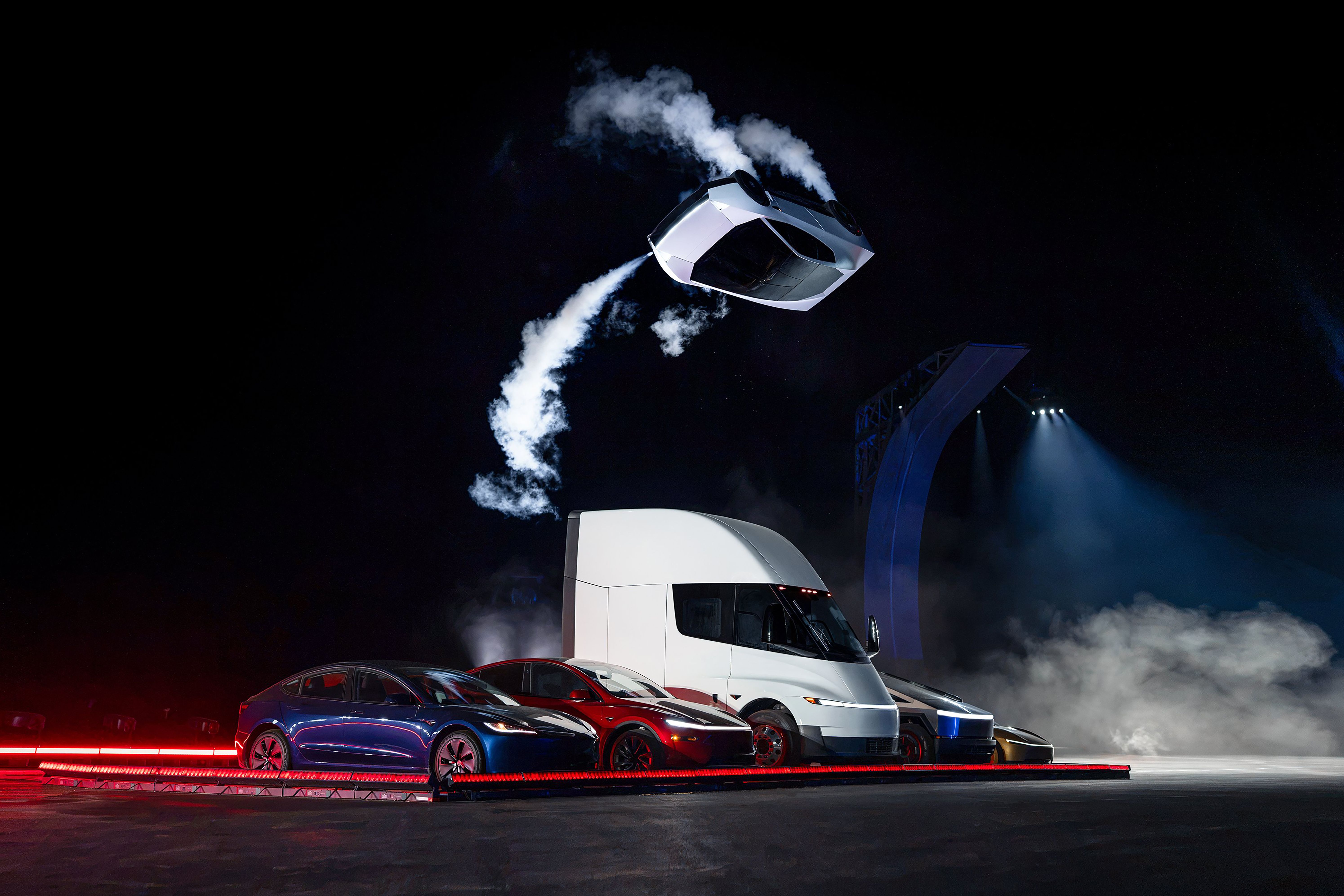 Fotografía cedida por Tesla donde aparece el prototipo de la nueva generación de su deportivo eléctrico Roadster sobrevolando invertido sobre varios autos este jueves en las instalaciones de pruebas de cohetes de SpaceX en McGregor, Texas. (EFE)