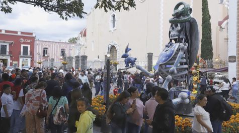 Personas observan catrinas monumentales instaladas en Atlixco, Puebla (México), como parte de las celebraciones del Día de Muertos. Las figuras, inspiradas en dioses prehispánicos, adornan distintos puntos del municipio. EFE/ Hilda Ríos